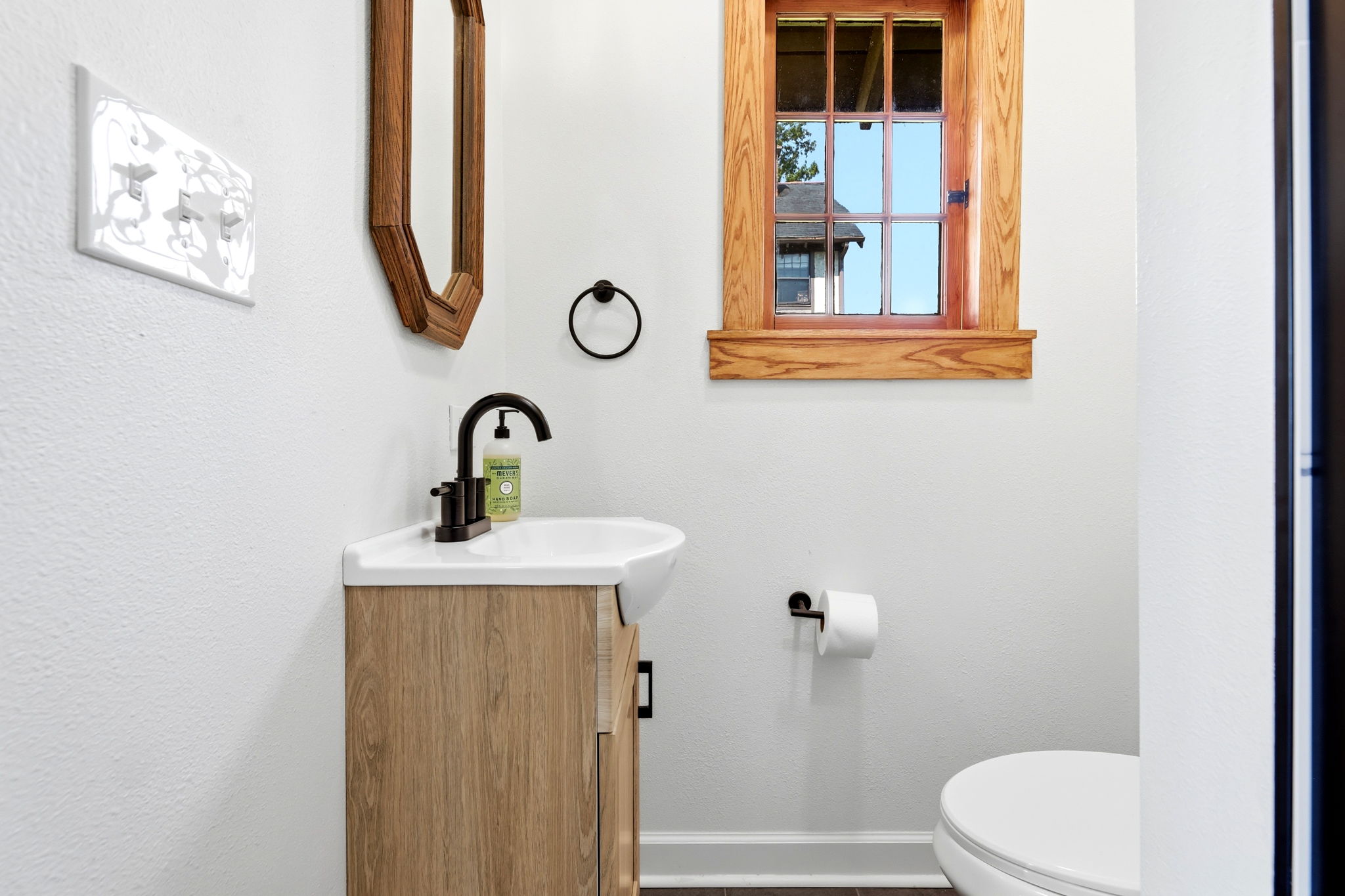 Carriage-house studio bathroom with sink, window, and toilet