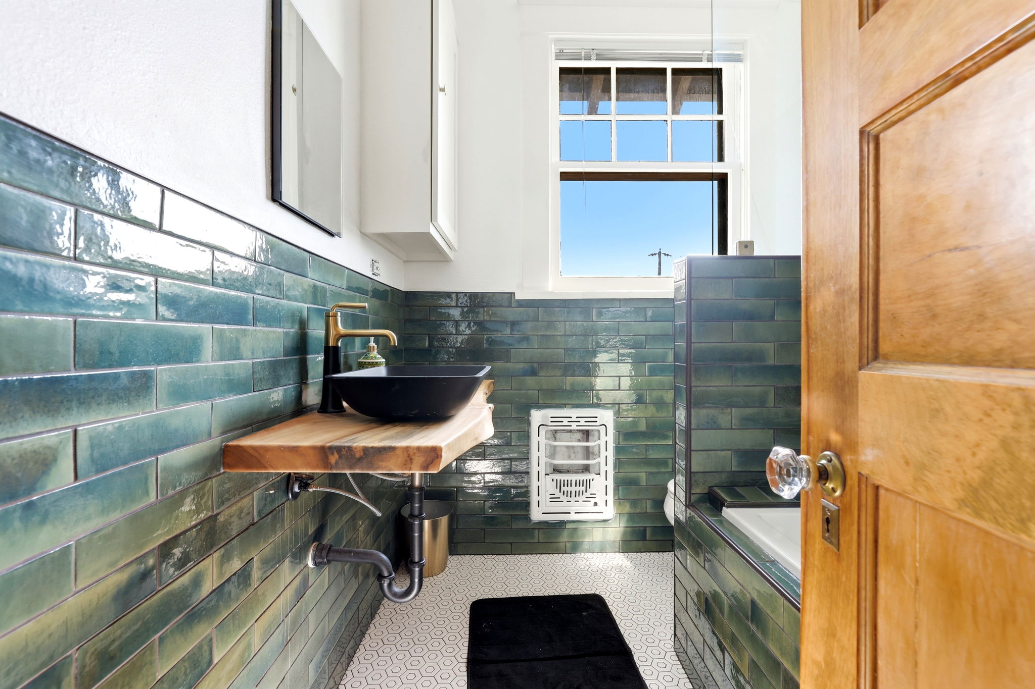 Remodeled bathroom with soaking tub and tile surround, view 1
