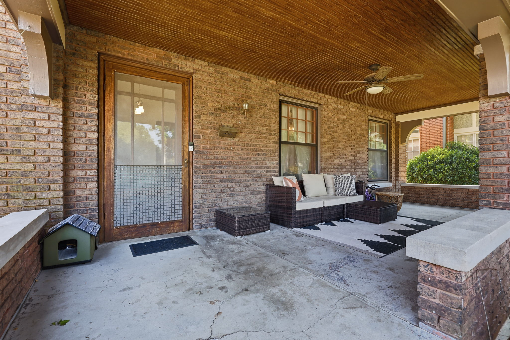 Deep front porch with iron spot brick and Craftsman woodwork